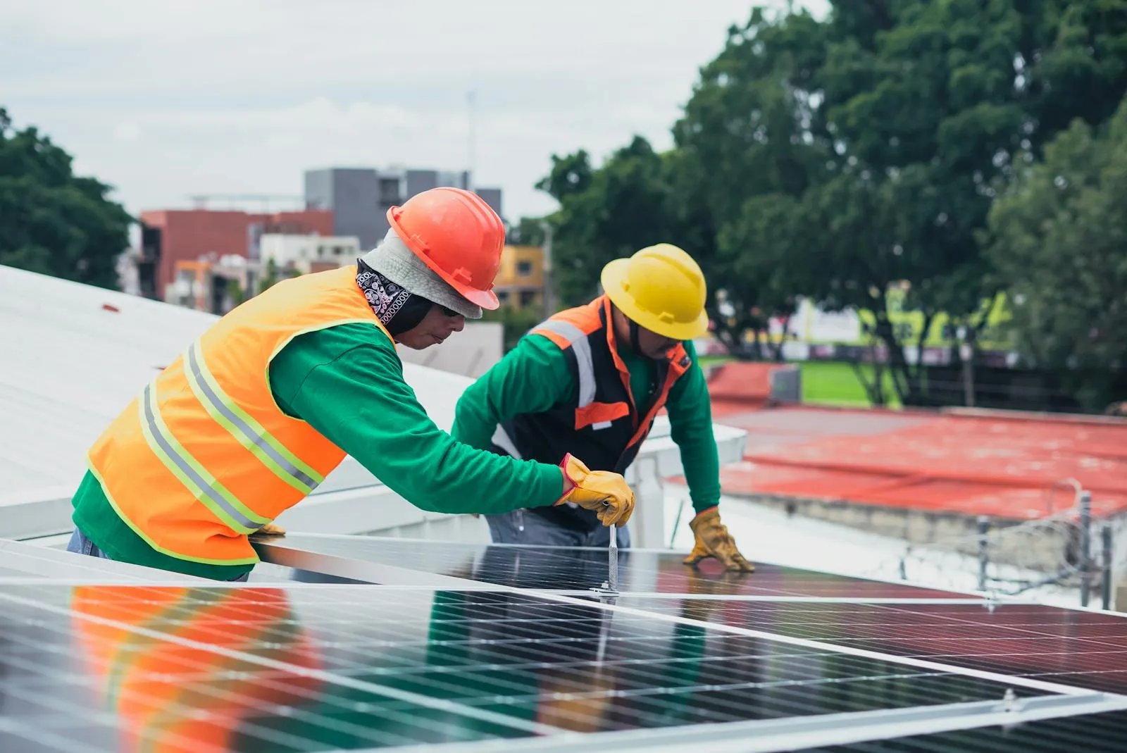 Zwei Monteure installieren Solarmodule auf einem Dach